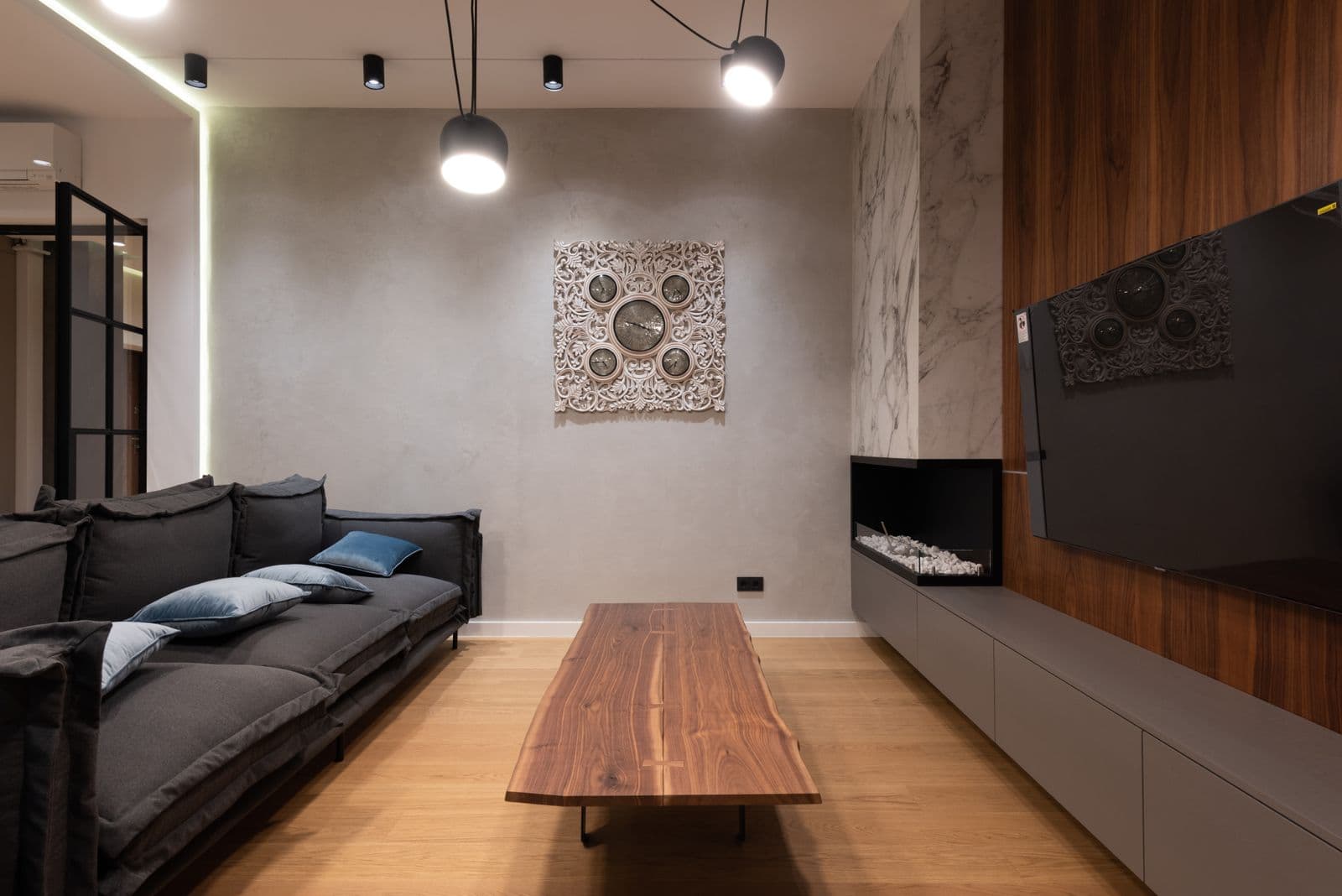 Bright modern apartment living room with a wall-mounted TV installed beside the fireplace