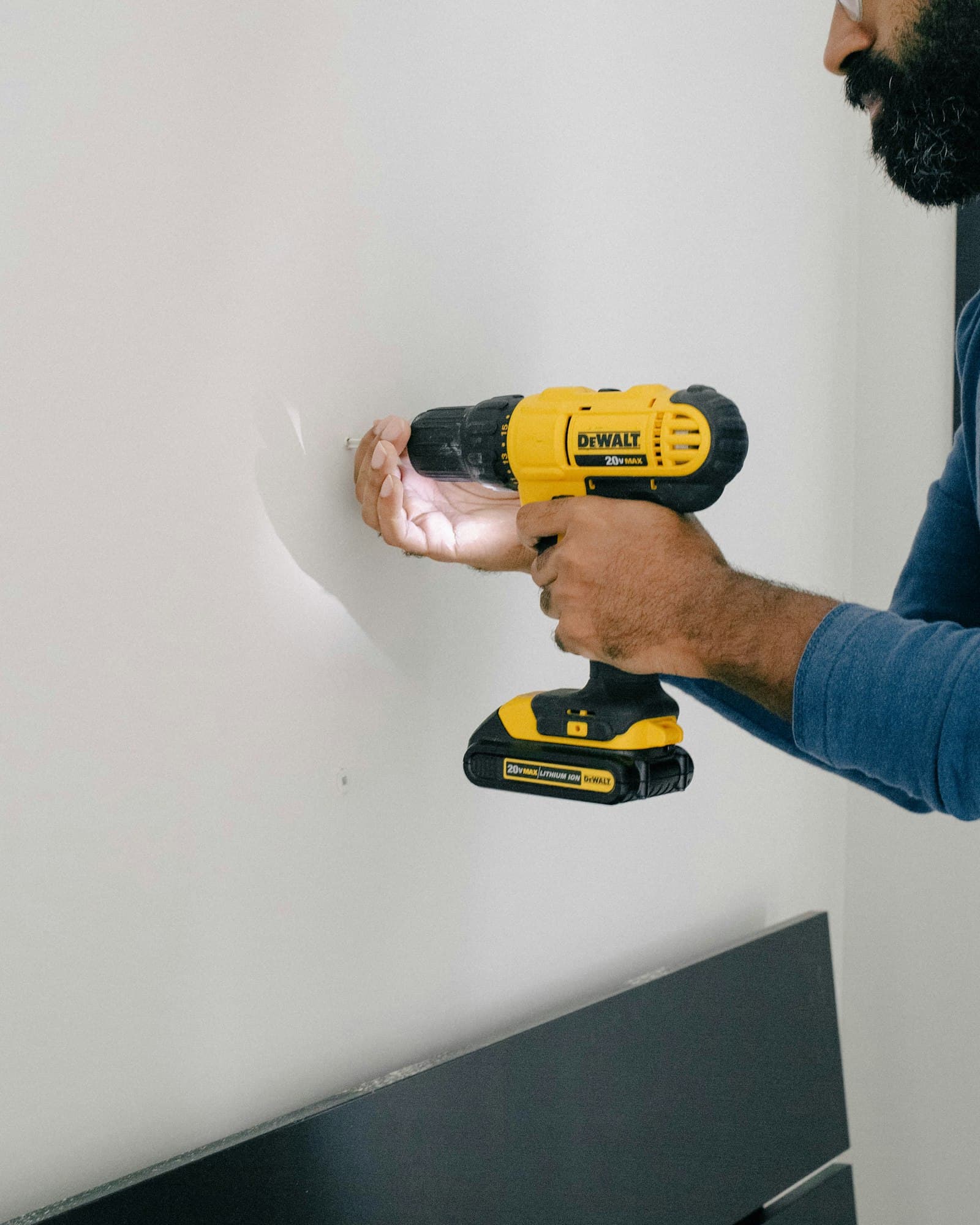 A technician drilling into the wall to anchor a TV mount, the kind of careful anchoring townhome walls in Memorial Heights call for