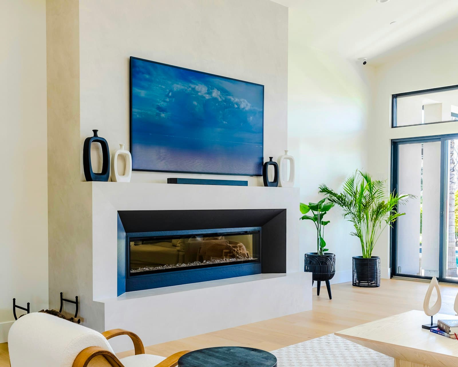 Bright modern living room with a TV and soundbar mounted flush above the fireplace