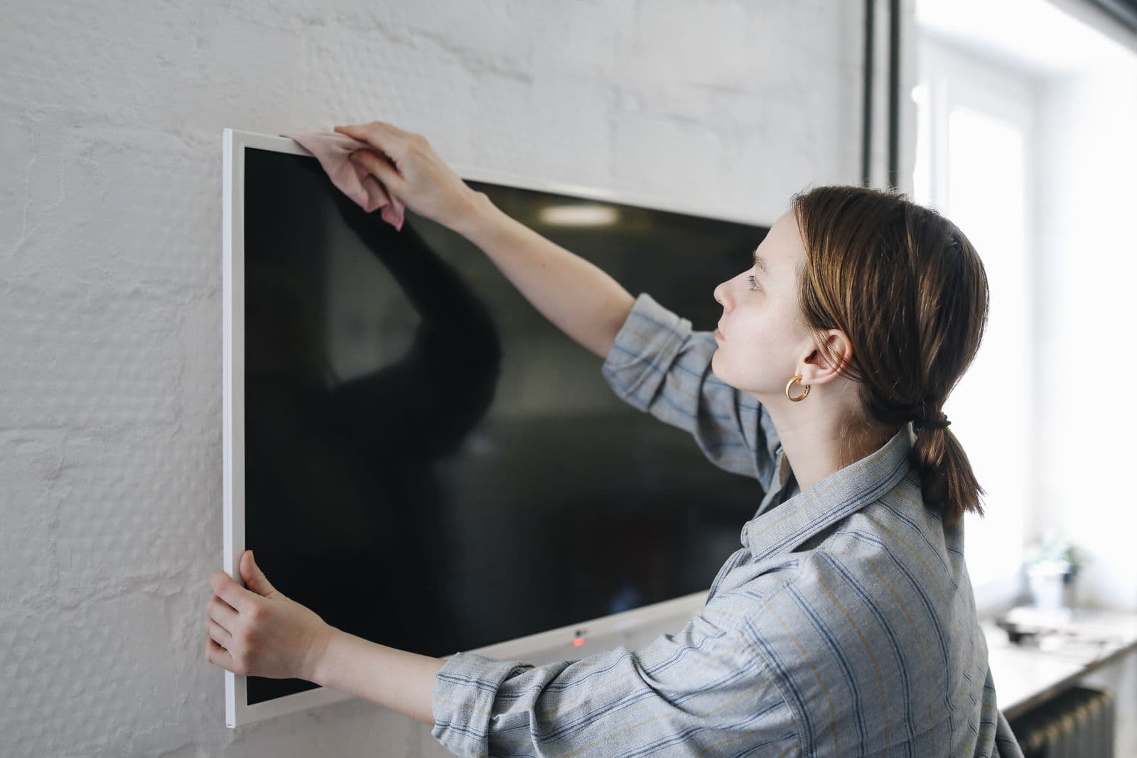 A flat-screen TV mounted flush on a wall, the kind of clean finished install Piney Point Village homes call for